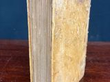 an old book sitting on top of a wooden table next to a blue wall