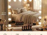 a bedroom with a bed and a mirror with lights on it