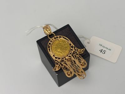 un pendentif en forme de main de Hamsa plaqué or, présenté dans un coffret noir