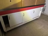 a white cabinet with a red stripe on the bottom