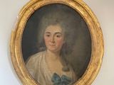 portrait of a lady in a white dress with a blue bow in a gold oval frame