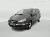 La camionnette noire est garée dans une pièce blanche au sol blanc.