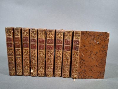 six vieux livres alignés sur une surface grise
