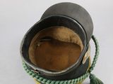 a black hat with a green tassel around it
