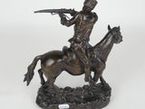 bronze statue of a man on a horse with a gun