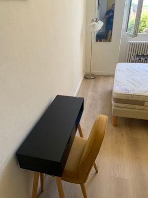 un petit bureau et une chaise dans un coin de la pièce