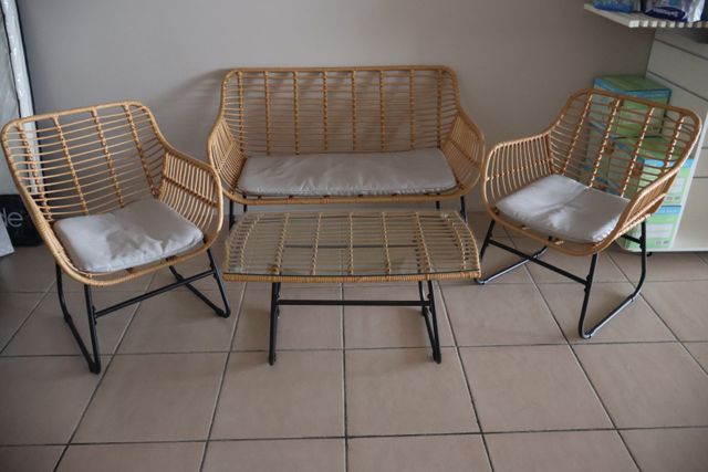 Un salon rotin et métal laqué noir : une banquette deux places, d...