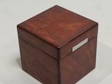 brown wooden box with silver plated lid on a white surface