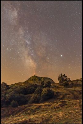 La Voie lactée brille de mille feux dans le ciel, au-dessus d'une colline verdoyante.