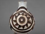 a white vase with a brown design on it