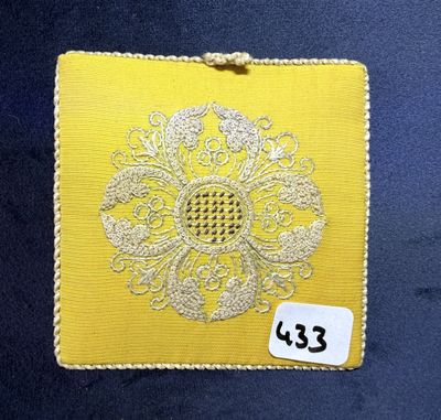 un gros plan sur un morceau de tissu jaune orné d'une fleur blanche