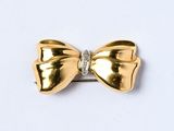 gold bow brooch with diamonds on a white background