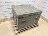 a metal box sitting on a pallet in front of a wall
