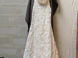 a wedding dress hanging on a hanger in a room