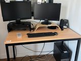 un bureau équipé de deux écrans et d'un clavier
