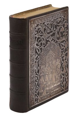 un vieux livre avec une couverture décorative sur fond blanc