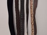 quatre ceintures accrochées à un crochet au mur