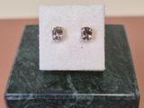 a close up of a pair of earrings sitting on top of a marble block