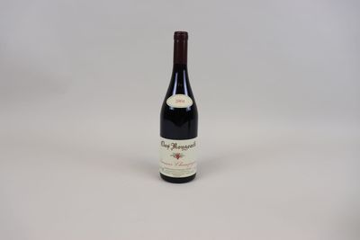 une bouteille de vin rouge posée sur une table blanche