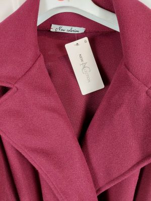 un gros plan d'un manteau rose suspendu à un cintre