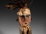 une image représentant une sculpture en bois d'un homme avec une plume sur la tête