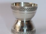 a silver bowl sitting on a table with a white background