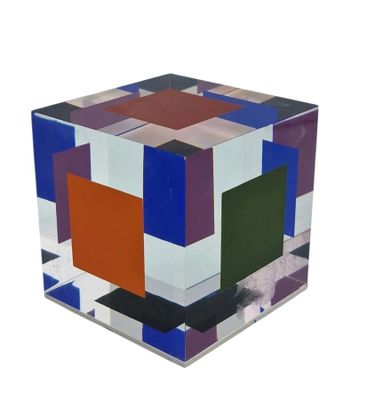 un cube multicolore posé sur une surface blanche
