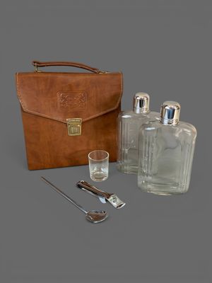 un étui en cuir contenant une bouteille, une cuillère et un verre