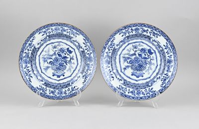 two blue and white plates with floral designs on them