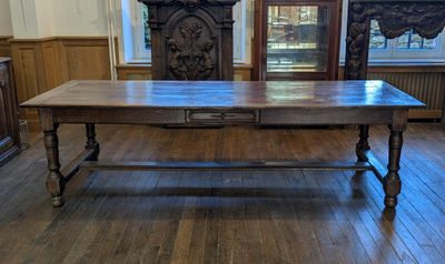 une grande table en bois au milieu d'une pièce