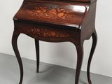 un bureau ancien orné d'un motif floral sur le plateau