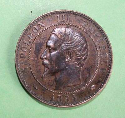 an old coin with a man ' s face on it on a green surface