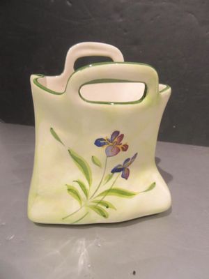 a small vase with a handle that has a flower painted on it