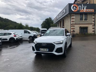 the audi q4 is parked in front of a building with cars parked in front of it