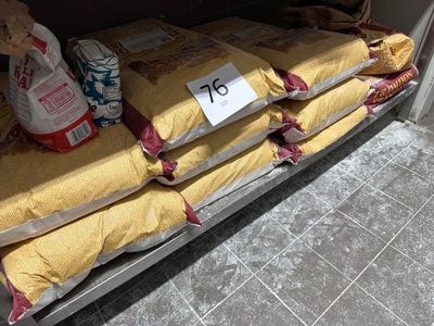Plusieurs sacs de riz sont empilés sur une étagère dans un magasin.