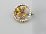 un gros plan d'une broche ornée de perles et d'une fleur