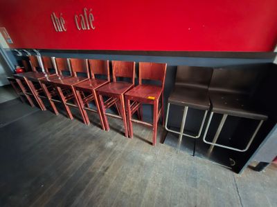 Au café, les tables et les chaises sont alignées contre le mur