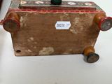 a small wooden box with a handle on wheels on a table