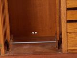 a cat that is sitting on the floor in front of a cabinet