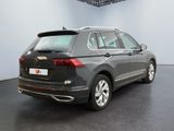 the rear end of a grey volkswagen suv parked in a garage
