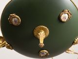 an image of a green vase with gold decorations on it