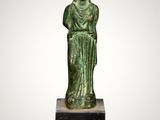 a green statue of a woman with a hat on her head