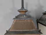 two lanterns that are on the wall next to each other