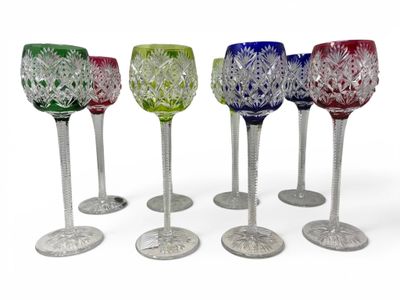 six different colored wine glasses sitting next to each other on a white surface