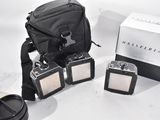 three cameras and a camera bag on a table