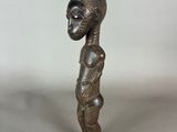 an old bronze statue of a woman with a large head
