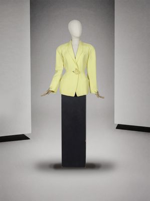 une photo d'un mannequin portant une veste jaune et une jupe noire