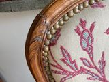 a close up of a chair with a red and blue floral pattern on it