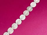 a close up of a silver bracelet on a pink background