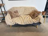 un ours en peluche allongé sur un canapé